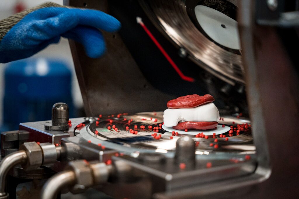 Preparação de material vermelho e branco numa prensa de discos de vinil Audiowax