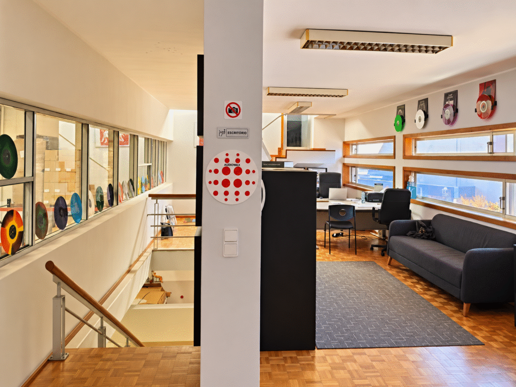 Espaço interior da Audiowax com escritório e discos de vinil em exposição junto à fábrica